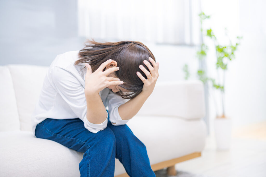 頭を抱えてうつむく女性